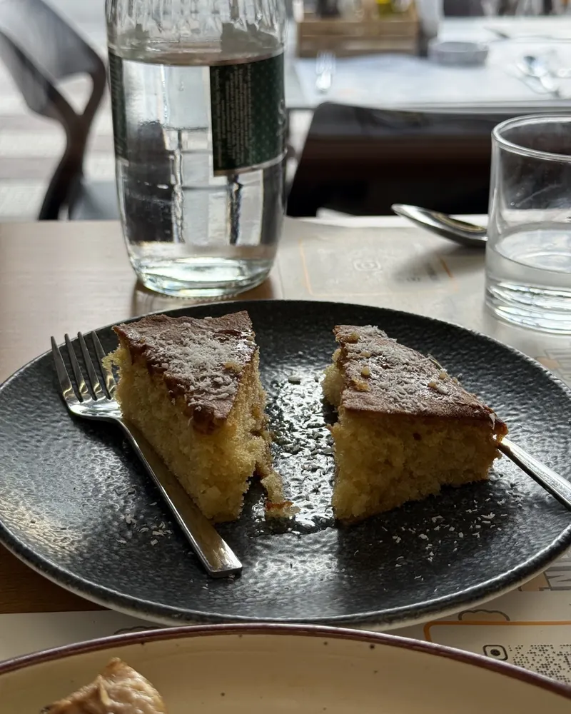 Two slices of syrup sponge cake on a dark plate